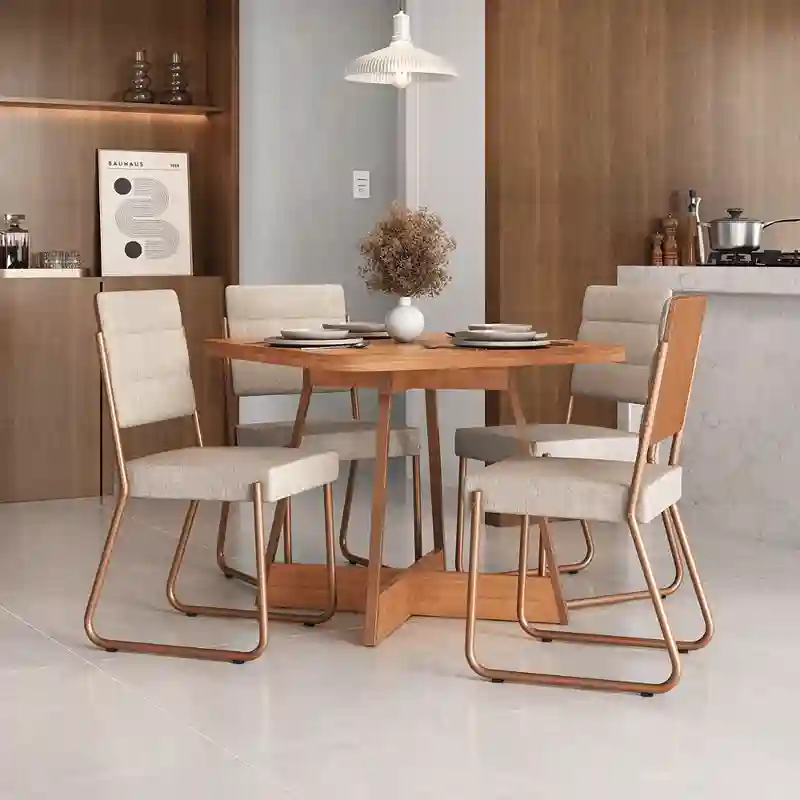 Conjunto de sala de jantar moderno com mesa quadrada de madeira e quatro cadeiras estofadas na cor creme com pernas de estrutura tubular metálica. O ambiente é clean, iluminado por uma luminária pendente branca e decorado com painel de madeira ao fundo.